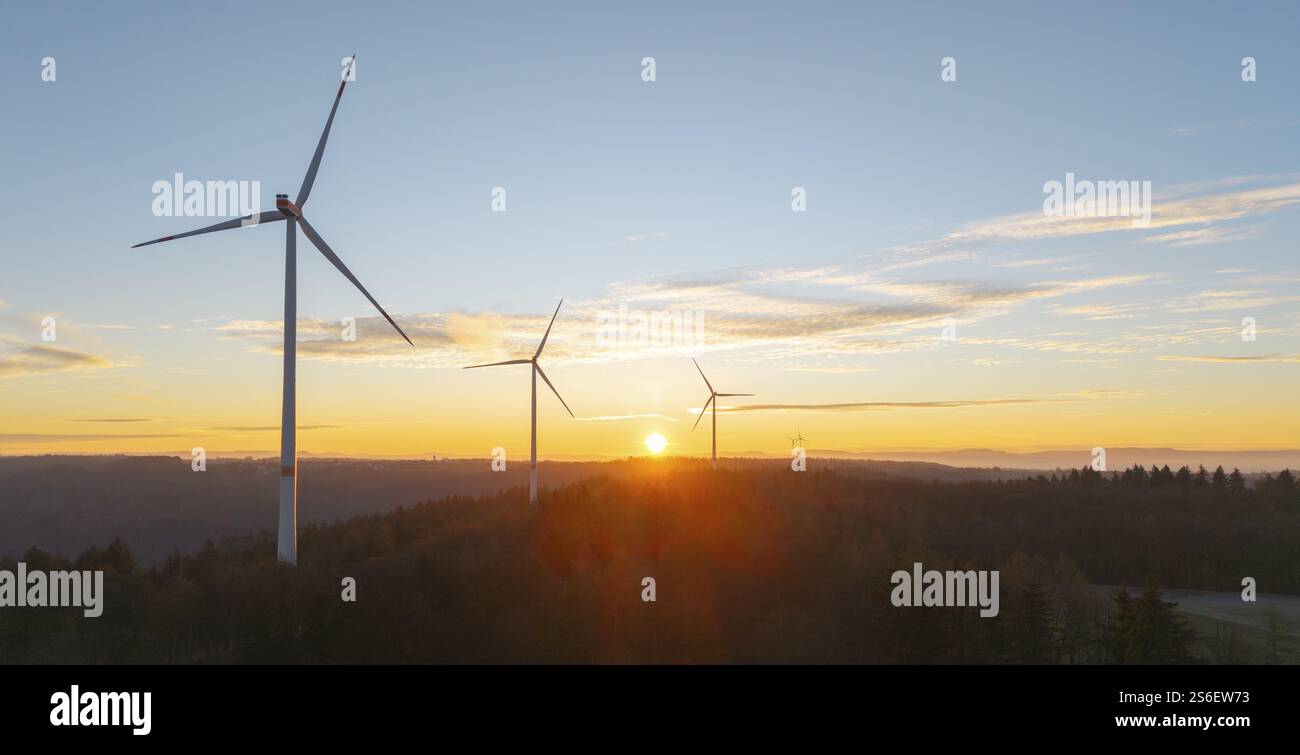 Alba dietro le turbine eoliche, luce radiosa penetra nel paesaggio, parco eolico, valle di Rems, Baden-Wuerttemberg, Germania, Europa Foto Stock
