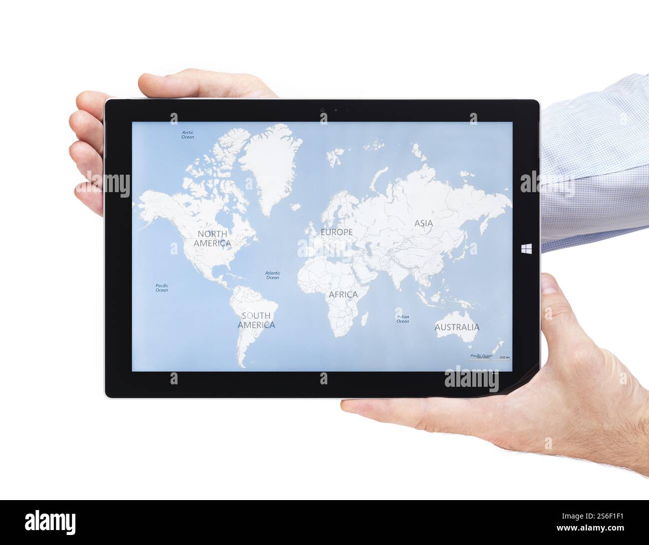 Persona mani Microsoft Surface Pro 3 computer tablet con mappa del mondo sulla sua visualizzazione isolata su sfondo bianco Foto Stock