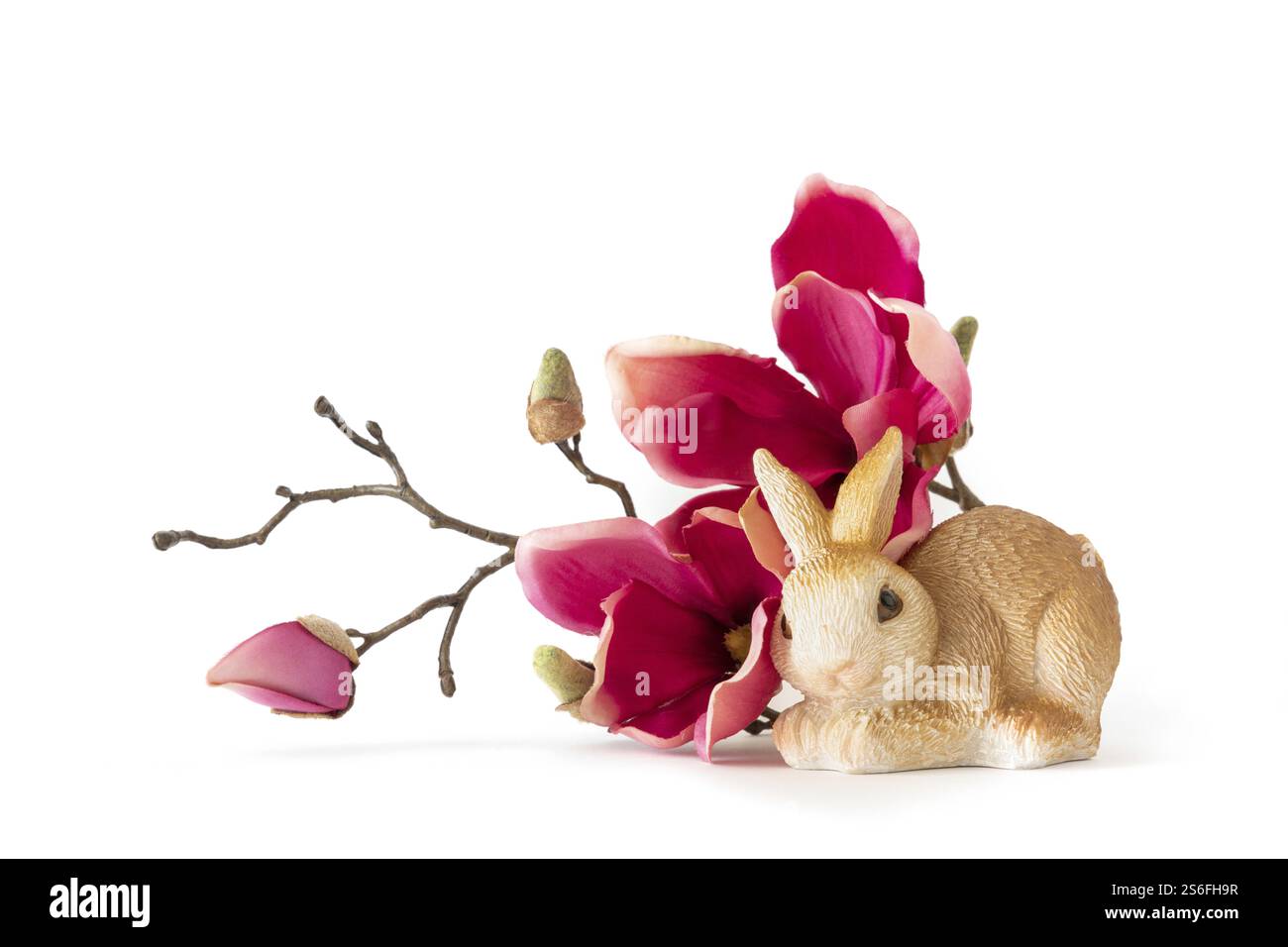 Un'immagine di un coniglietto pasquale seduto su alcuni fiori rossi di magnolia Foto Stock
