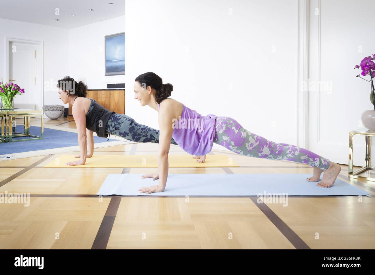 Due donne che fanno yoga a casa in posa Foto Stock