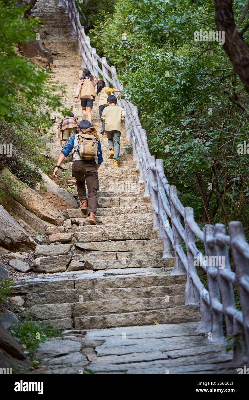 Felice insegnante e bambini che camminano in montagna Foto Stock