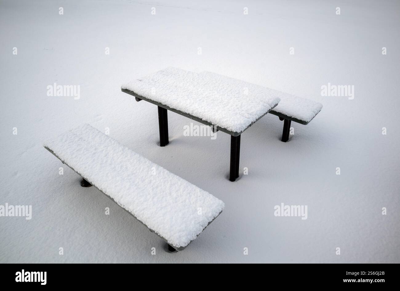 Panche coperte di neve e tavolo nel parco Foto Stock