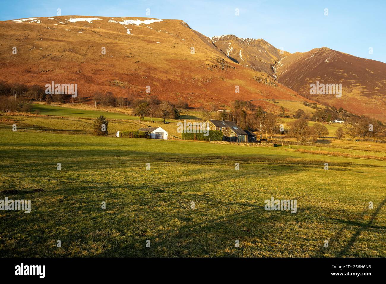 Pascolo ruvido e cottage moderni sotto la grandiosità del Lakeland settentrionale Fell 'Saddleback', Threlkeld, Westmorland & Furness, Cumbria, Regno Unito Foto Stock
