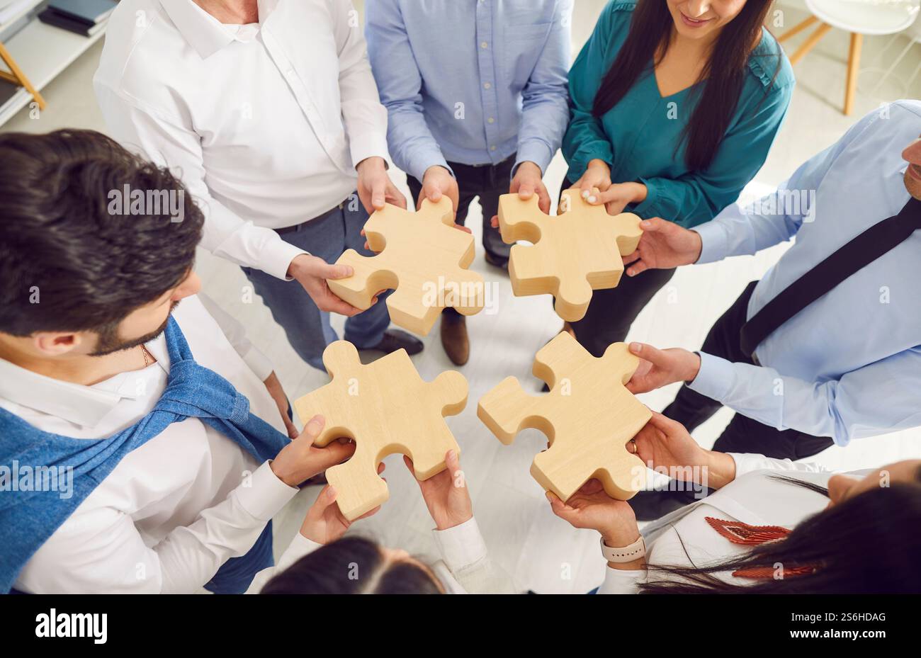 Gruppo di uomini d'affari che collegano puzzle in legno in ufficio Foto Stock