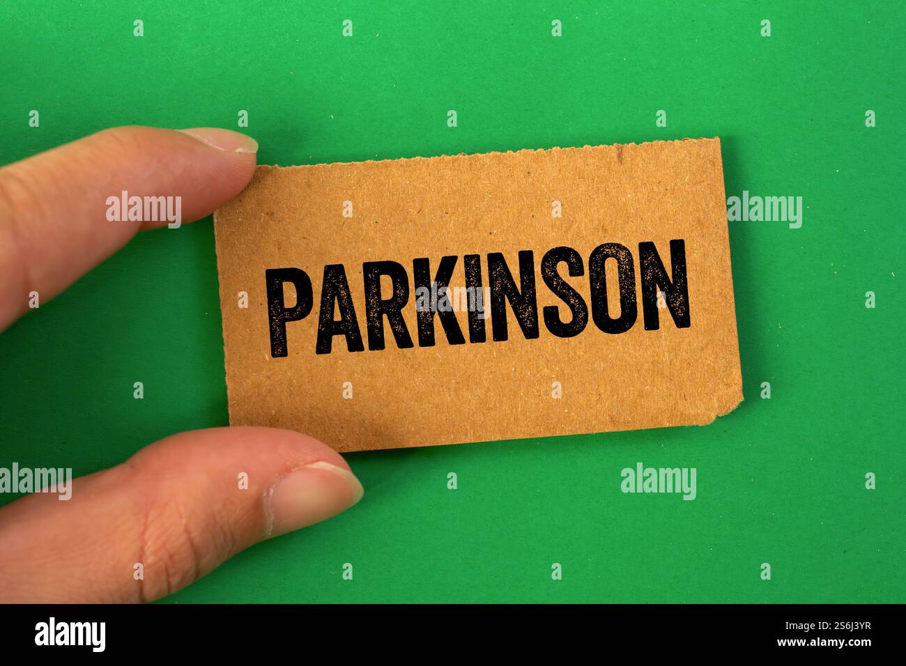 Messaggio Parkinson scritto su carta di cartone su sfondo verde. Simbolo del parkinson concettuale. Copia spazio. Foto Stock
