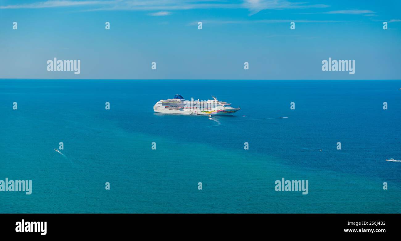 Grande nave da crociera circondata da barche nel tranquillo Mare Blu, Thailandia Foto Stock