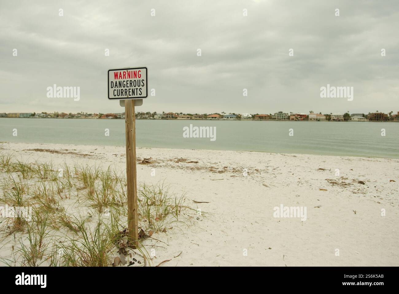 Avviso correnti pericolose segnalano il cartello di Pass A Grille Dog Beach. Guardando verso Bay Channel. Sulla sabbia e sull'avena verde del mare. St. Pete Beach, Florida, su un clo Foto Stock