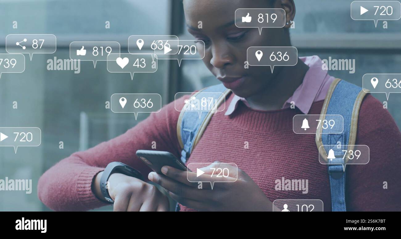 Immagine di icone dei media su una donna afroamericana che usa lo smartphone in città Foto Stock