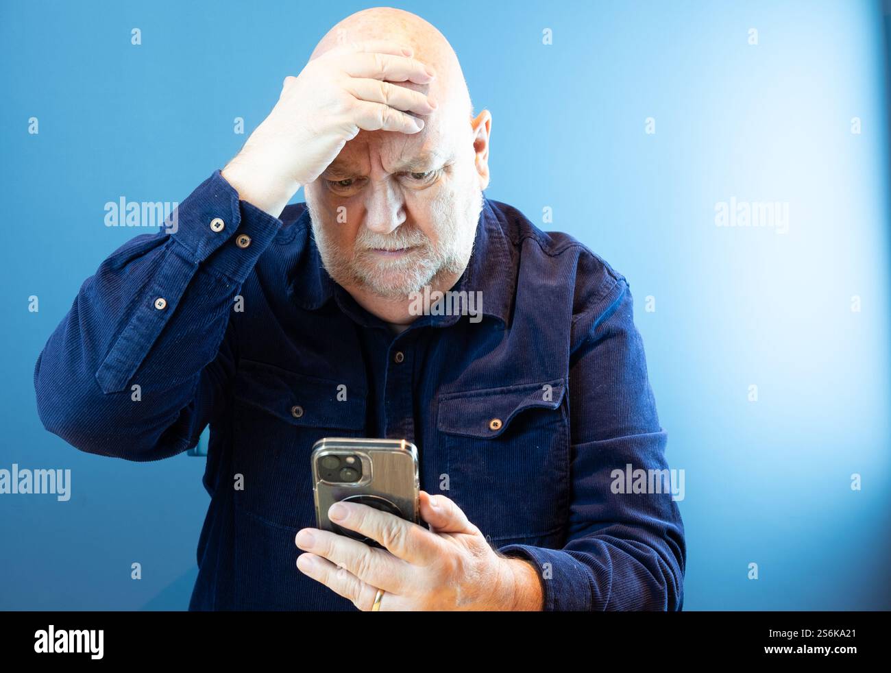 Persona anziana preoccupata per le frodi online e per essere truffata su uno smartphone Foto Stock