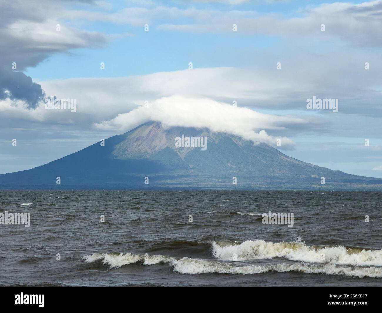 Splendida vista del vulcano parzialmente avvolto da nuvole, vista dalla calma riva del lago nelle giornate limpide. Foto Stock
