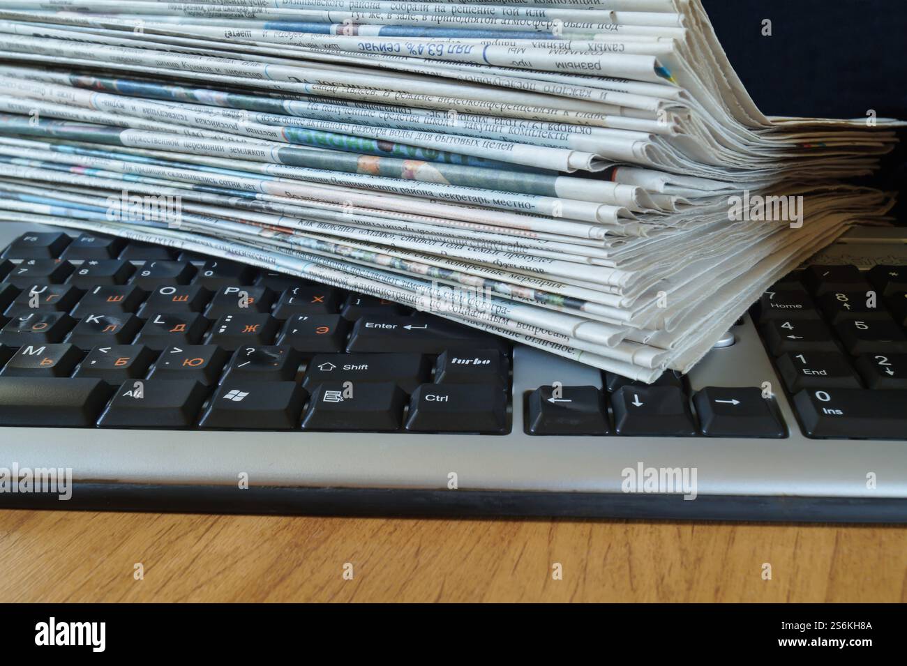 Sulla tastiera del computer è presente una pila di giornali Foto Stock