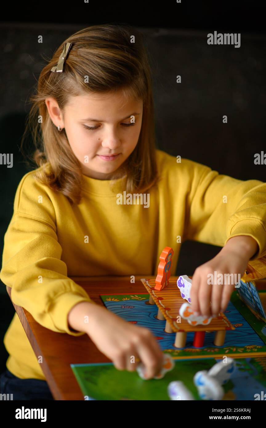 Una ragazza gioca ai giochi da tavolo, godendosi il divertimento e la sfida. Foto Stock