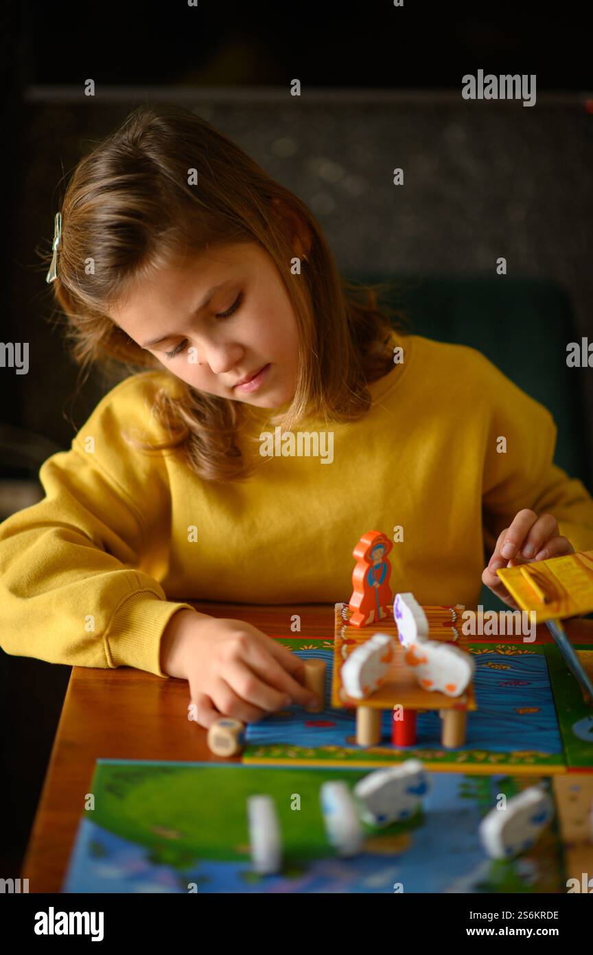 Una ragazza gioca ai giochi da tavolo, godendosi il divertimento e la sfida. Foto Stock