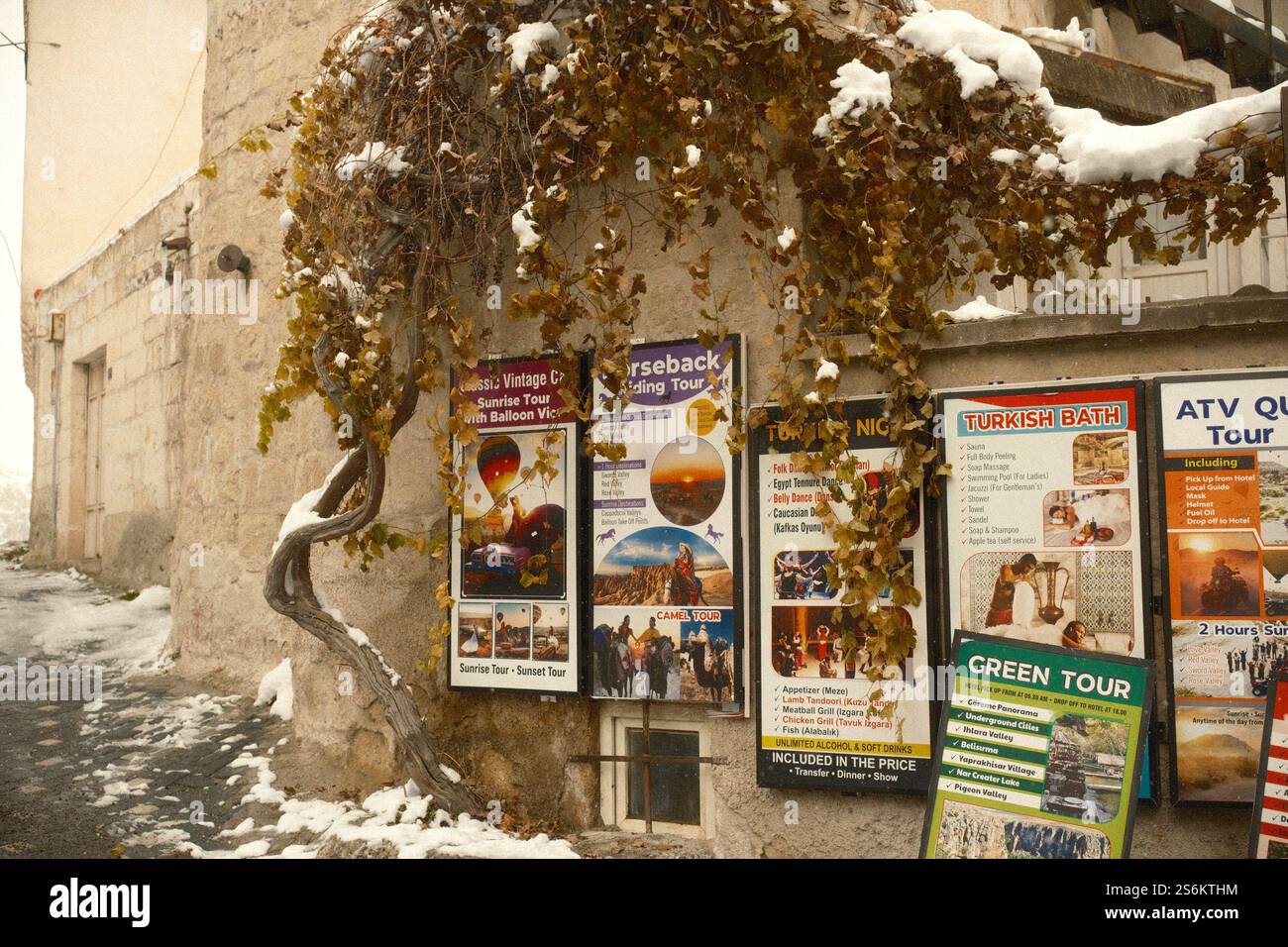 Goreme, Cappadocia, Türkiye : vari volantini che pubblicizzano pacchetti turistici, come attrazioni, attività ed esperienze, pubblicati sulle mura della città Foto Stock