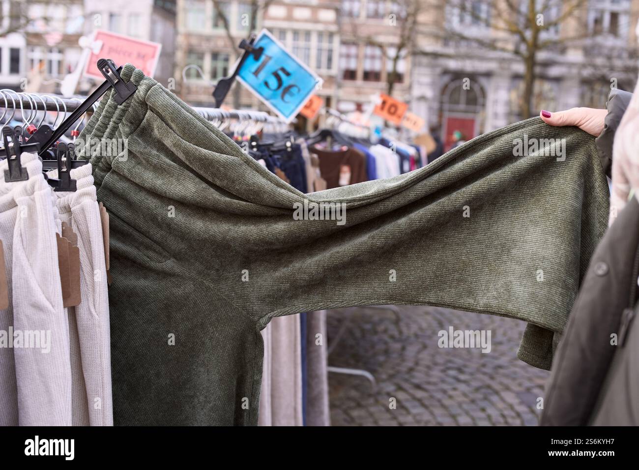 Donna che sceglie i vestiti in un mercato delle pulci all'aperto in belgio. Turismo belga Foto Stock