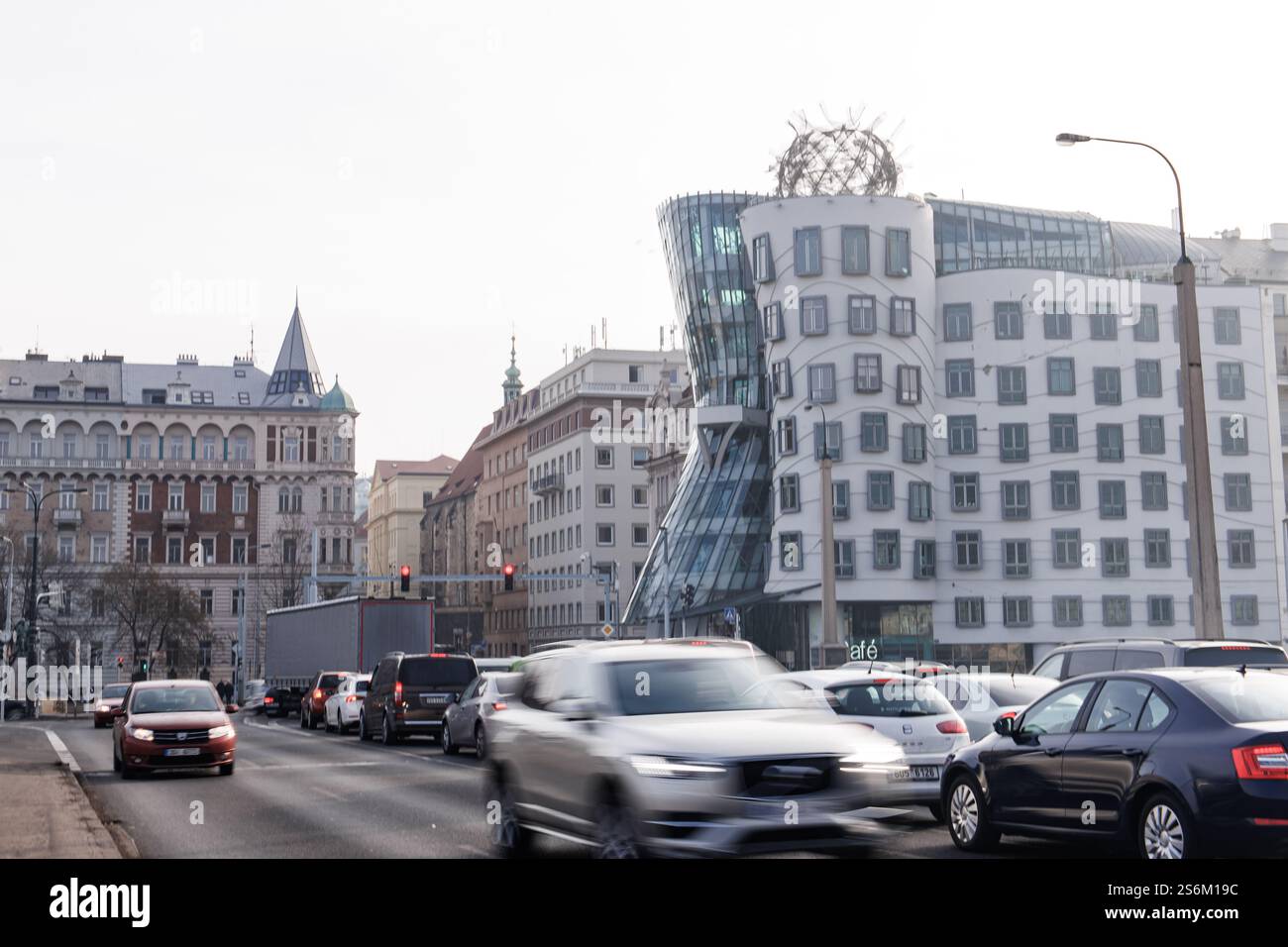 Praga, repubblica Ceca - 16 febbraio 2023: Auto che guidano sulla strada di fronte alla casa da ballo, un edificio di uffici decostruttivisti noto anche come f Foto Stock