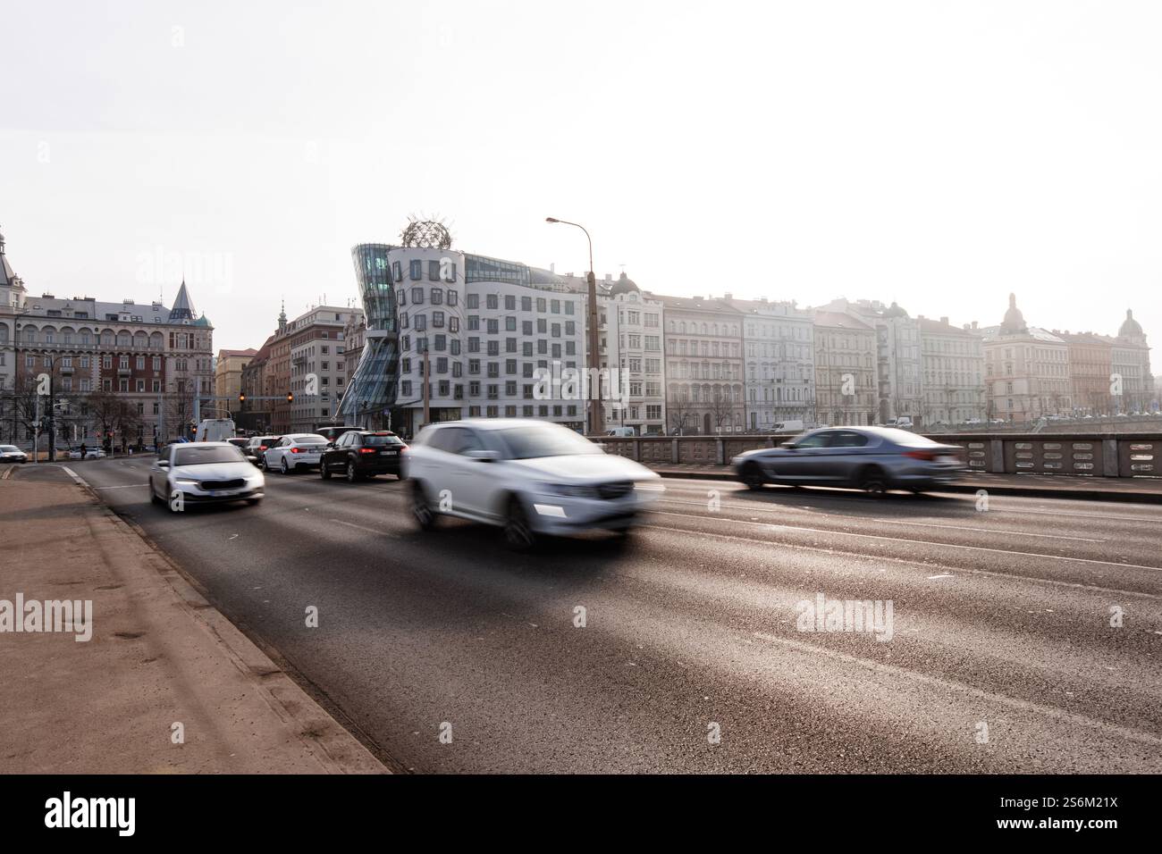Praga, repubblica Ceca - 16 febbraio 2023: Auto sfocate che guidano sul ponte jiraskuv a praga con la casa da ballo sullo sfondo Foto Stock