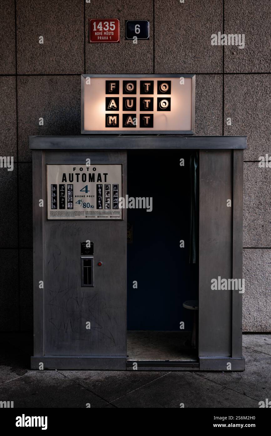 Praga, repubblica Ceca - 16 febbraio 2023: Vecchio stand fotografico in piedi su una strada, insegna illuminata e superfici usurate che aggiungono un fascino vintage Foto Stock