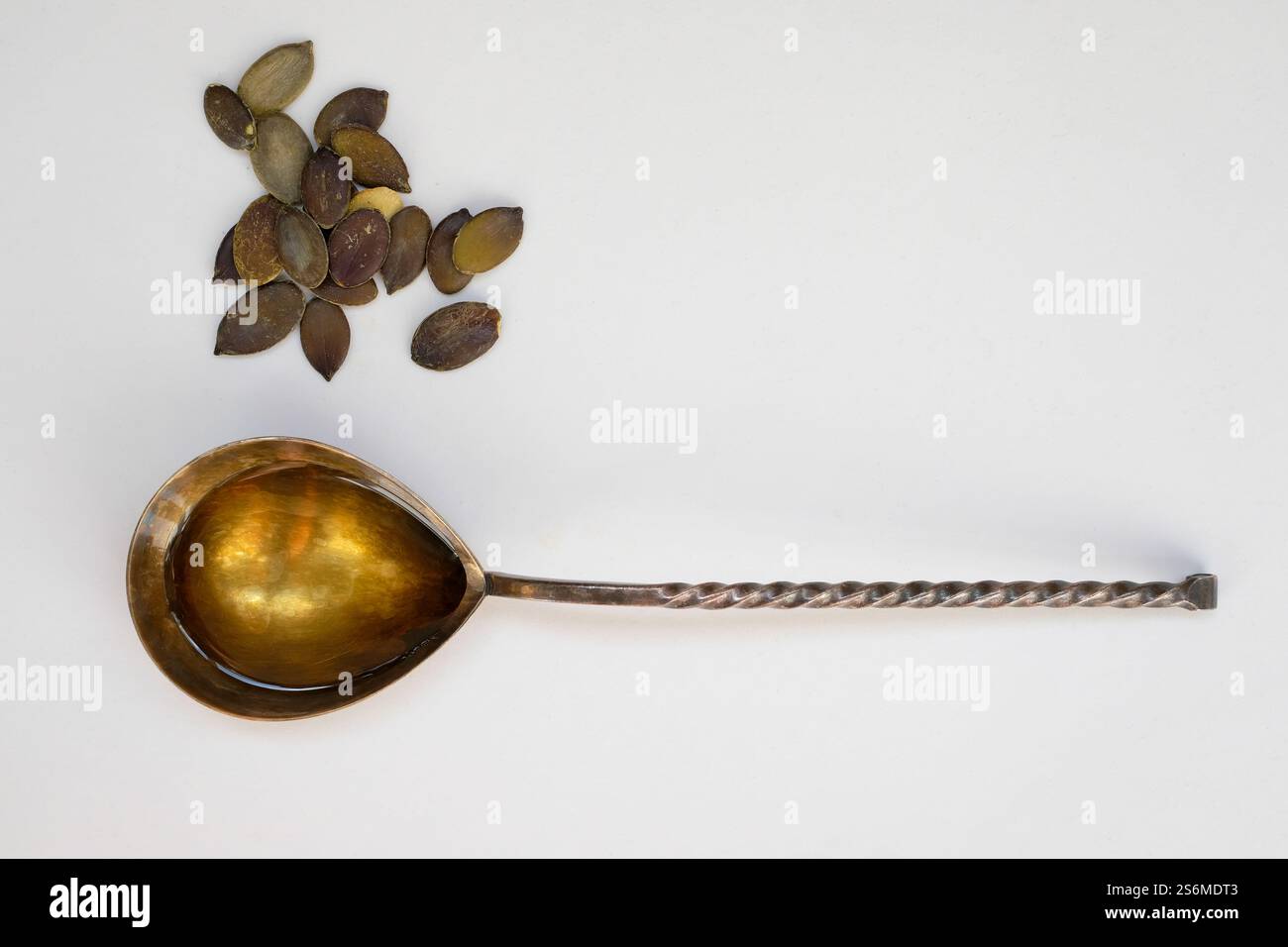 Olio di semi di zucca nel cucchiaio di metallo. Copia spazio. Minimalismo. Foto Stock