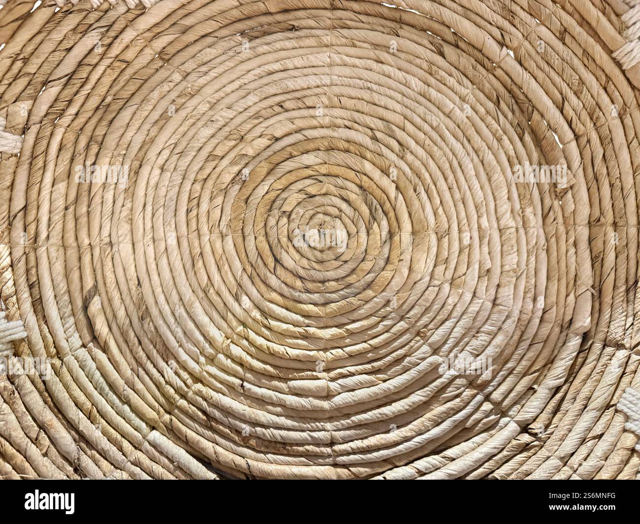 Arte e artigianato a spirale casuale in rattan o vimini, cesto in rattan sintetico rotondo a spirale o decorazione a parete. Foto Stock