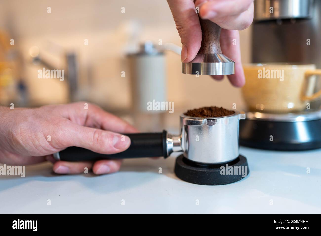 Barista Tamping caffè appena macinato per espresso Foto Stock