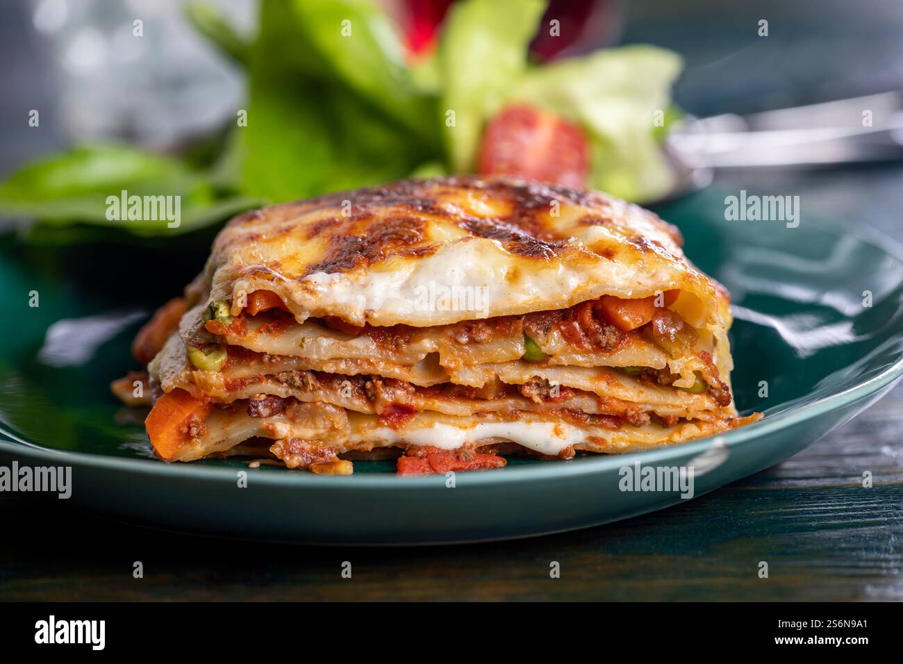 Lasagne italiane su un piatto verde Foto Stock