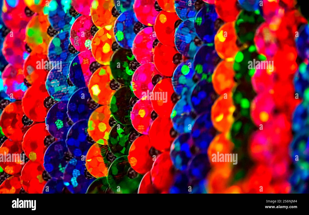Le paillettes colorate cucite su un capo di abbigliamento riflettono la luce Foto Stock