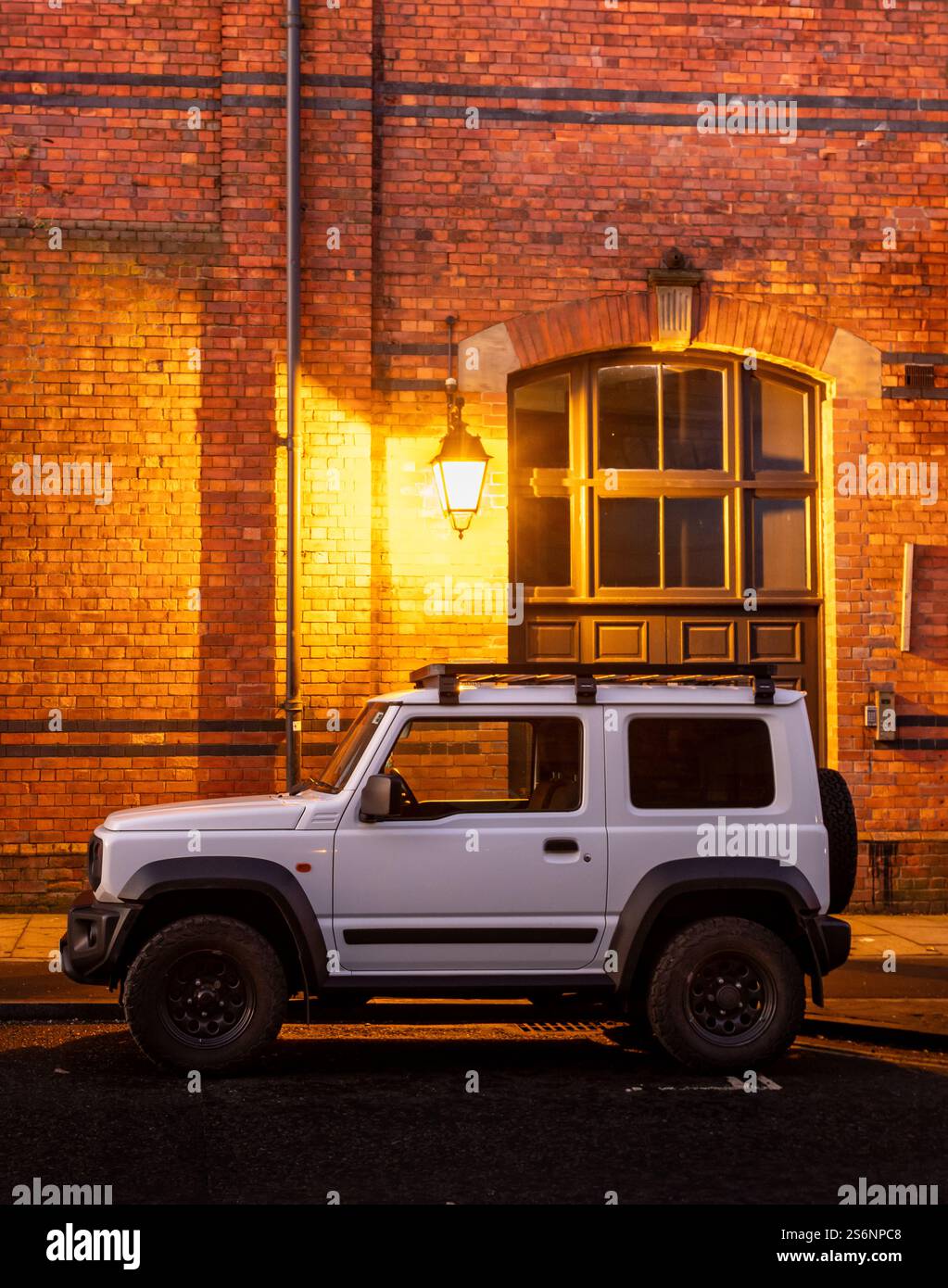 Un'auto bianca parcheggiata di fronte a un edificio sul lato Gateshead del Ponte di alto livello Foto Stock
