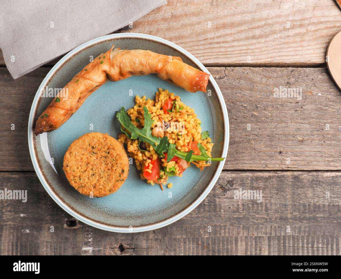 Gustoso Falafel con bulgur piccante e un rotolo di pasta vegetariano su un piatto di ceramica, tradizionale cibo caldo, vista dall'alto Foto Stock