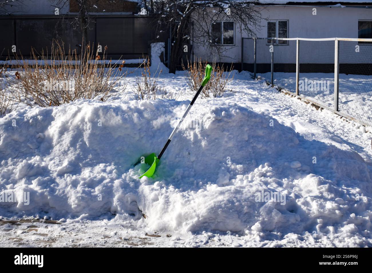 Rimozione della neve nel cortile posteriore, spalatura invernale, lavori domestici invernali, rimozione della neve nel vialetto Foto Stock
