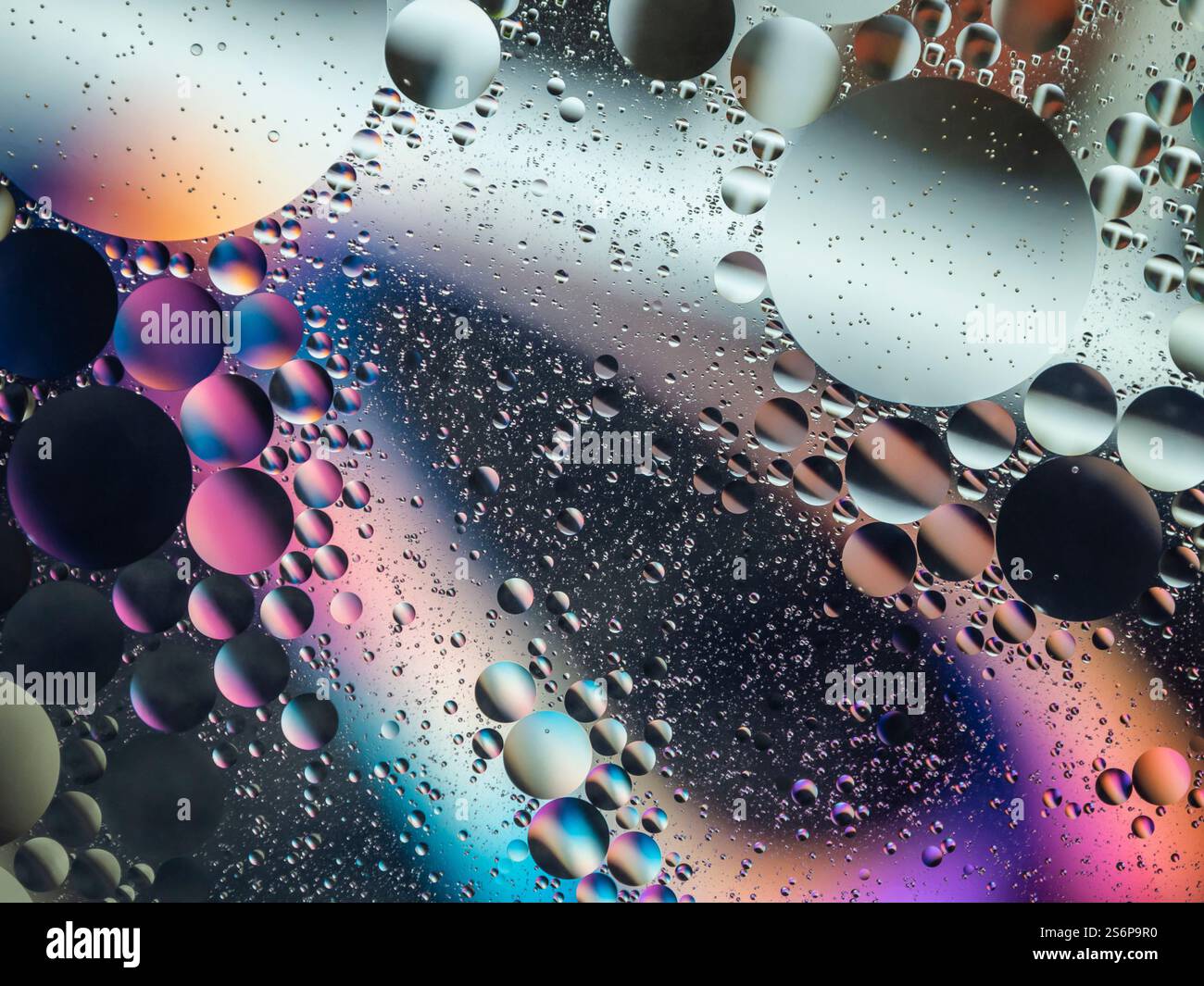 Immagine astratta vibrante con bolle d'acqua e olio colorate che creano un motivo testurizzato. Perfetto per ambienti artistici, scientifici o creativi. Foto Stock