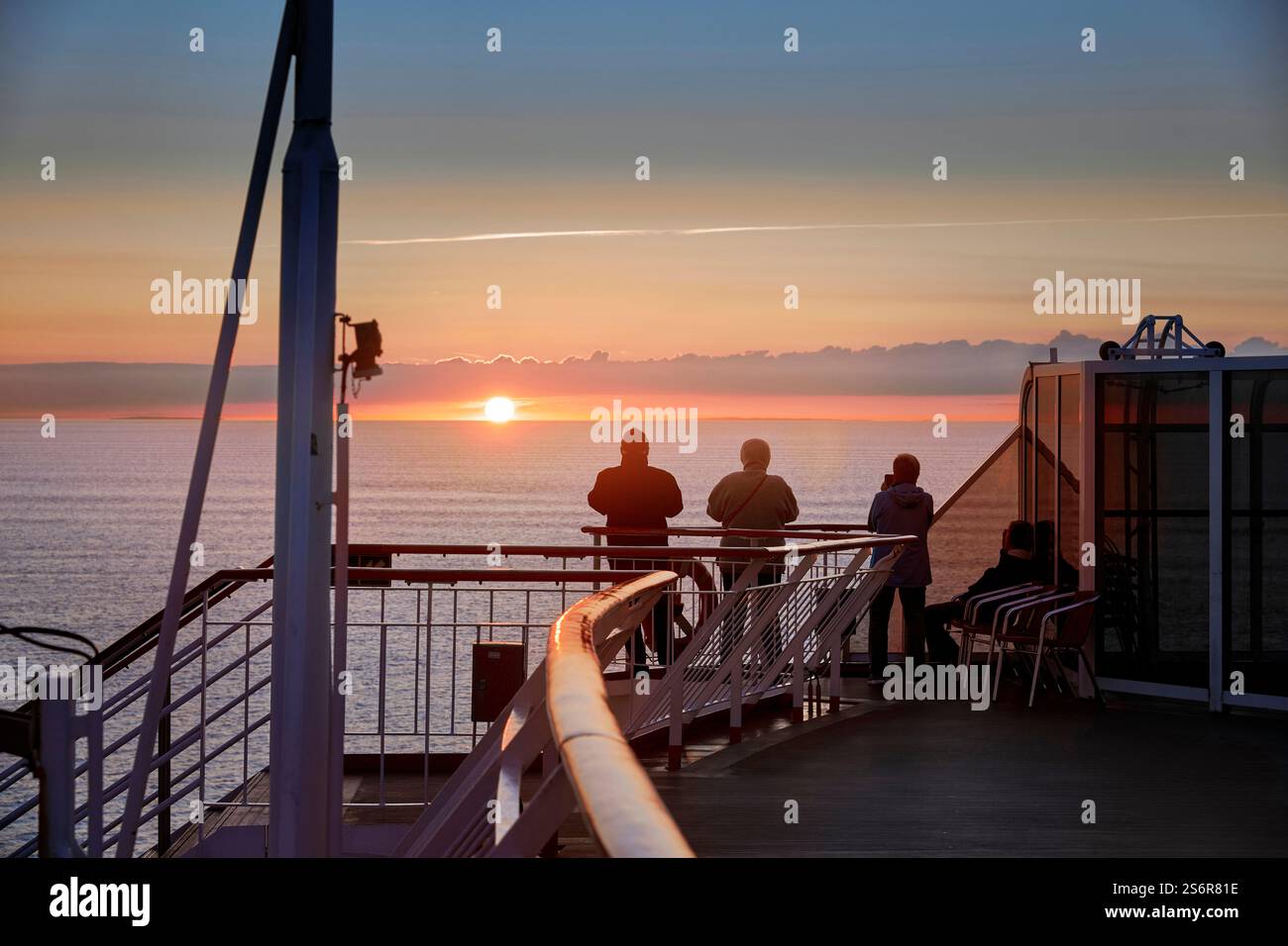 Gita in barca, passeggeri sul ponte meravigliati al tramonto sul mare, vista dell'orizzonte e infinita distesa, romantica atmosfera serale Foto Stock