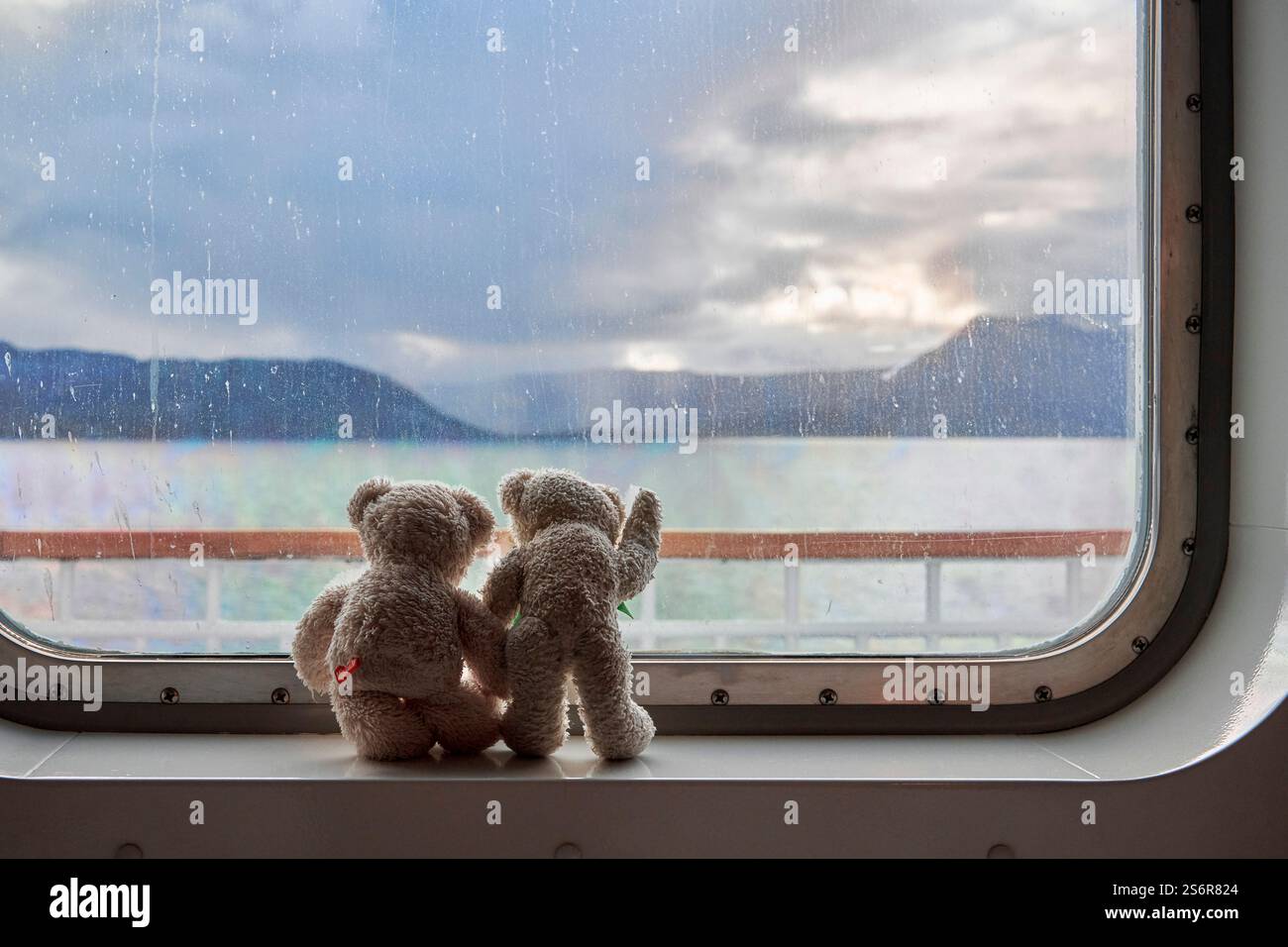 Gita in barca con i bambini, giocattoli morbidi si affacciano sul mare dalla finestra della cabina Foto Stock