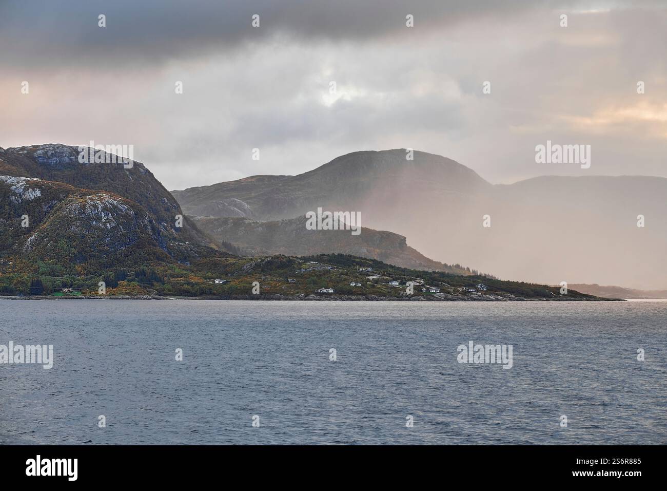 Naviga lungo la costa della Norvegia, la costa frastagliata e le montagne di Helgeland nella nebbia mattutina Foto Stock