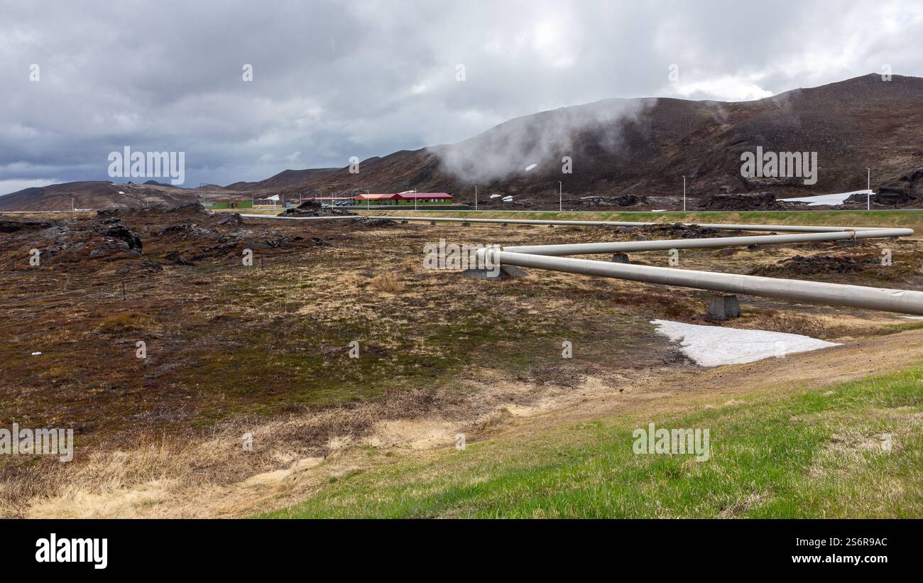Sistema di distribuzione di tubi geotermici e infrastrutture presso la centrale geotermica Krafla in Islanda, con campi di lava nera intorno. Foto Stock