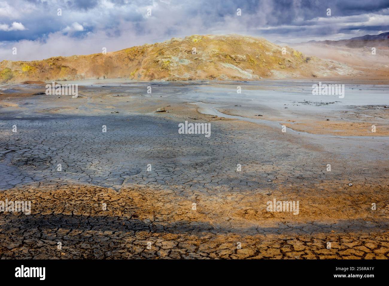 Paesaggio vulcanico di Hverir, area geotermica di Myvatn in Islanda, con terreno cranizzato arancione e piscine termali e ruscelli. Foto Stock