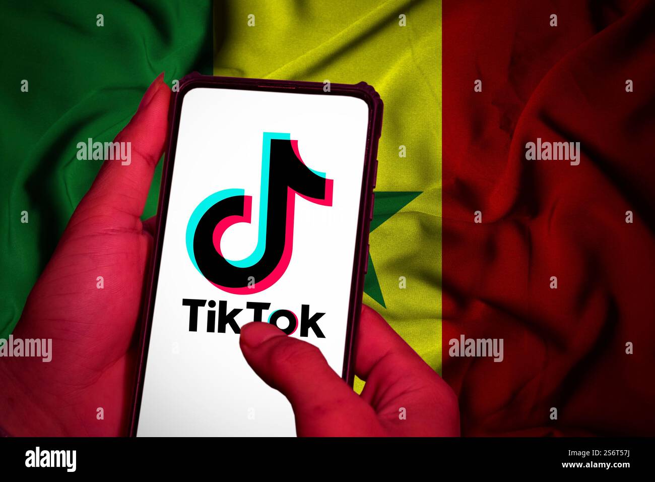 Pringsewu, lampung; 21 gennaio 2025; schermo cellulare con logo tiktok in mano a un uomo con la bandiera senegalese sullo sfondo Foto Stock