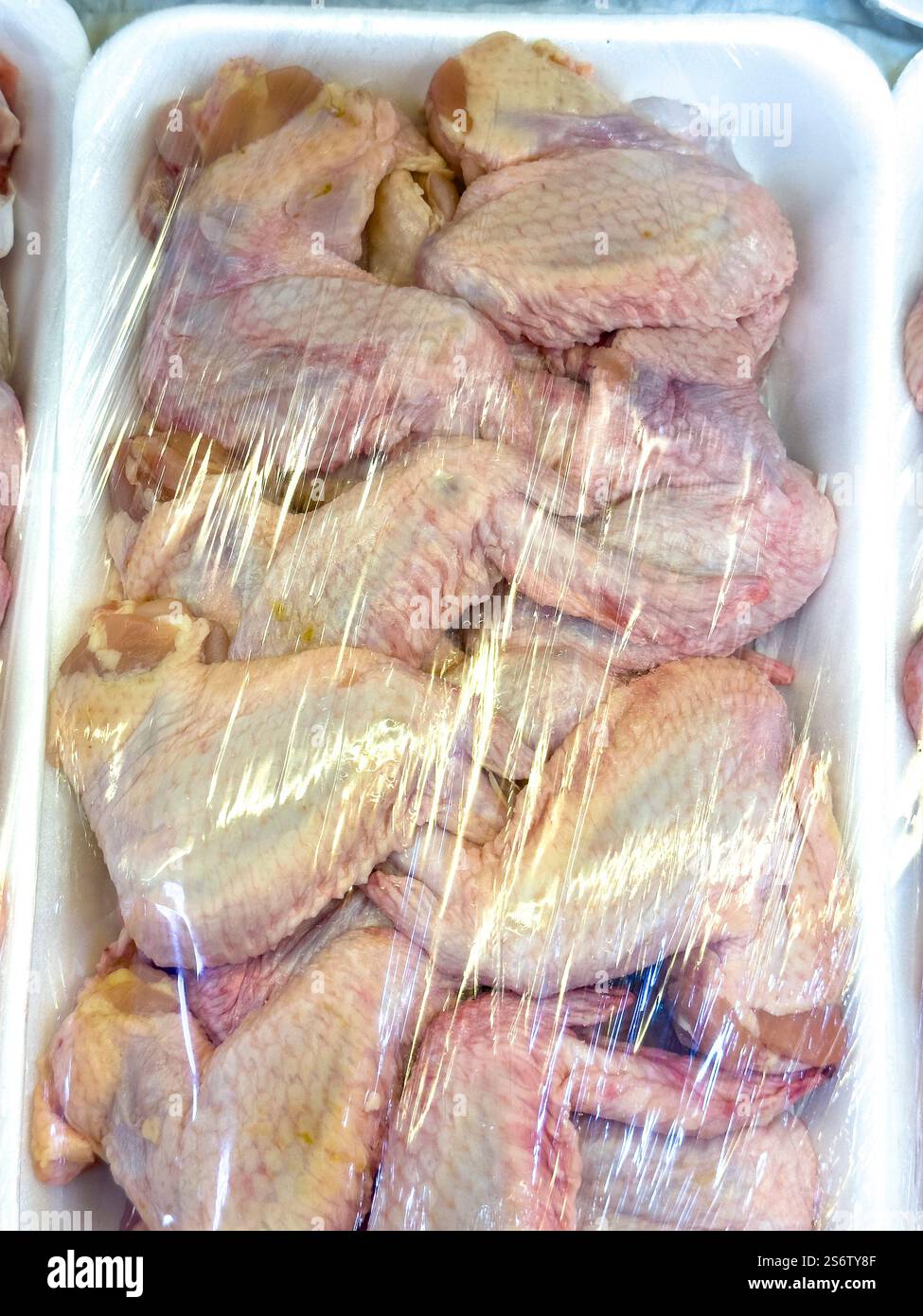 Scaffale del supermercato, ali di pollo nella loro confezione Foto Stock