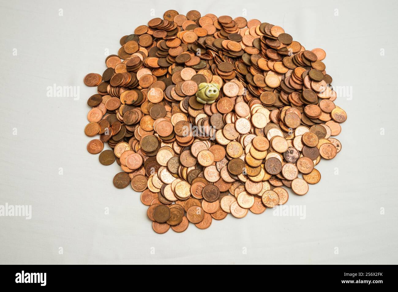 Una pila di monete canadesi da un cent che non è più in uso con un piccolo maiale in cima Foto Stock