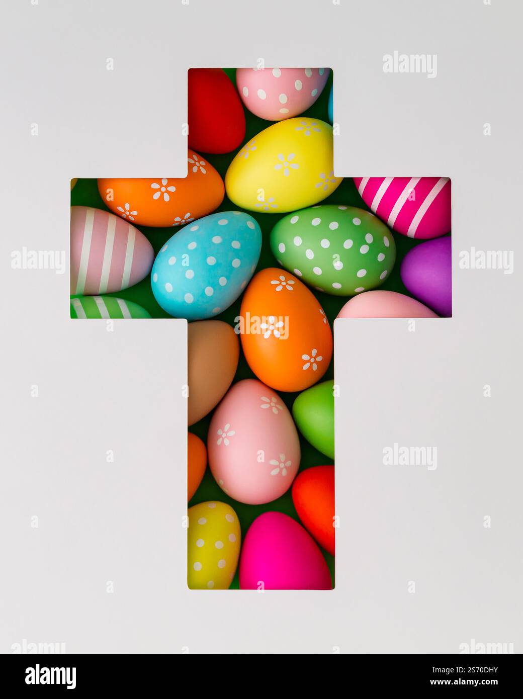 Composizione primaverile con uova di Pasqua colorate visibili attraverso una fessura a forma di croce su sfondo bianco. Concetto di Pasqua minimalista. Un'idea creativa per le vacanze. Foto Stock