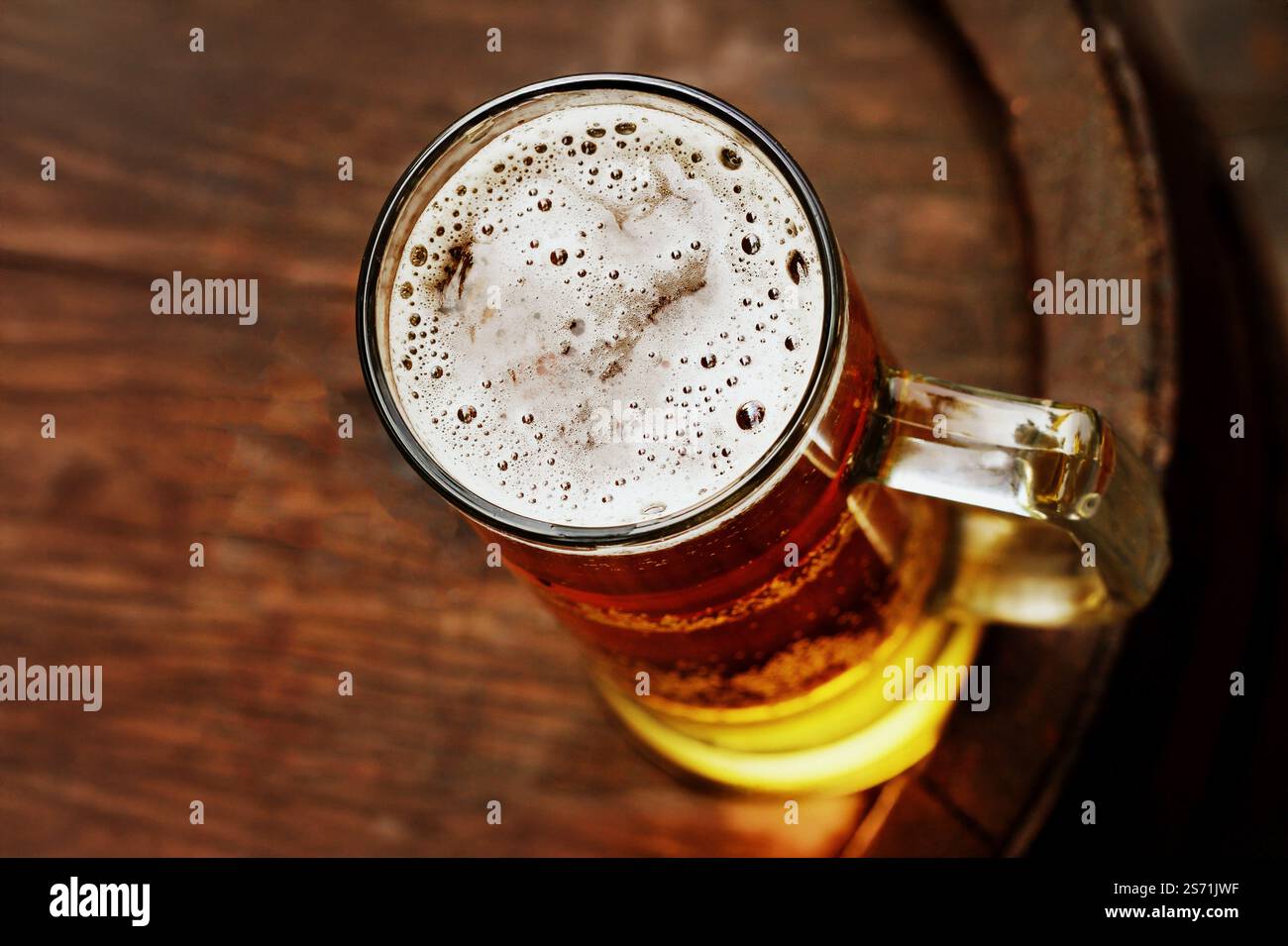 Bicchiere di birra su vecchio barile di legno. Foto Stock
