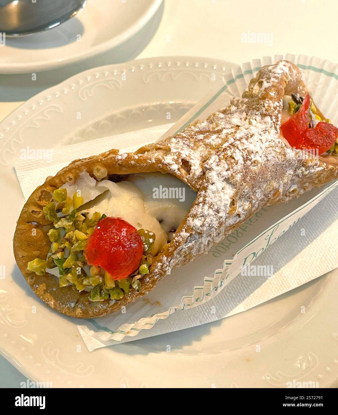 Canoli con pistacchi su piattino. Cibo e bevande. Dolce tradizionale italiano. Foto Stock
