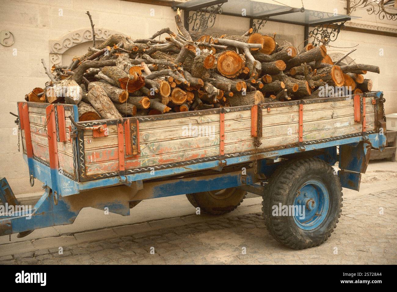 Rimorchio trattore agricolo con carico di tronchi di legno Foto Stock