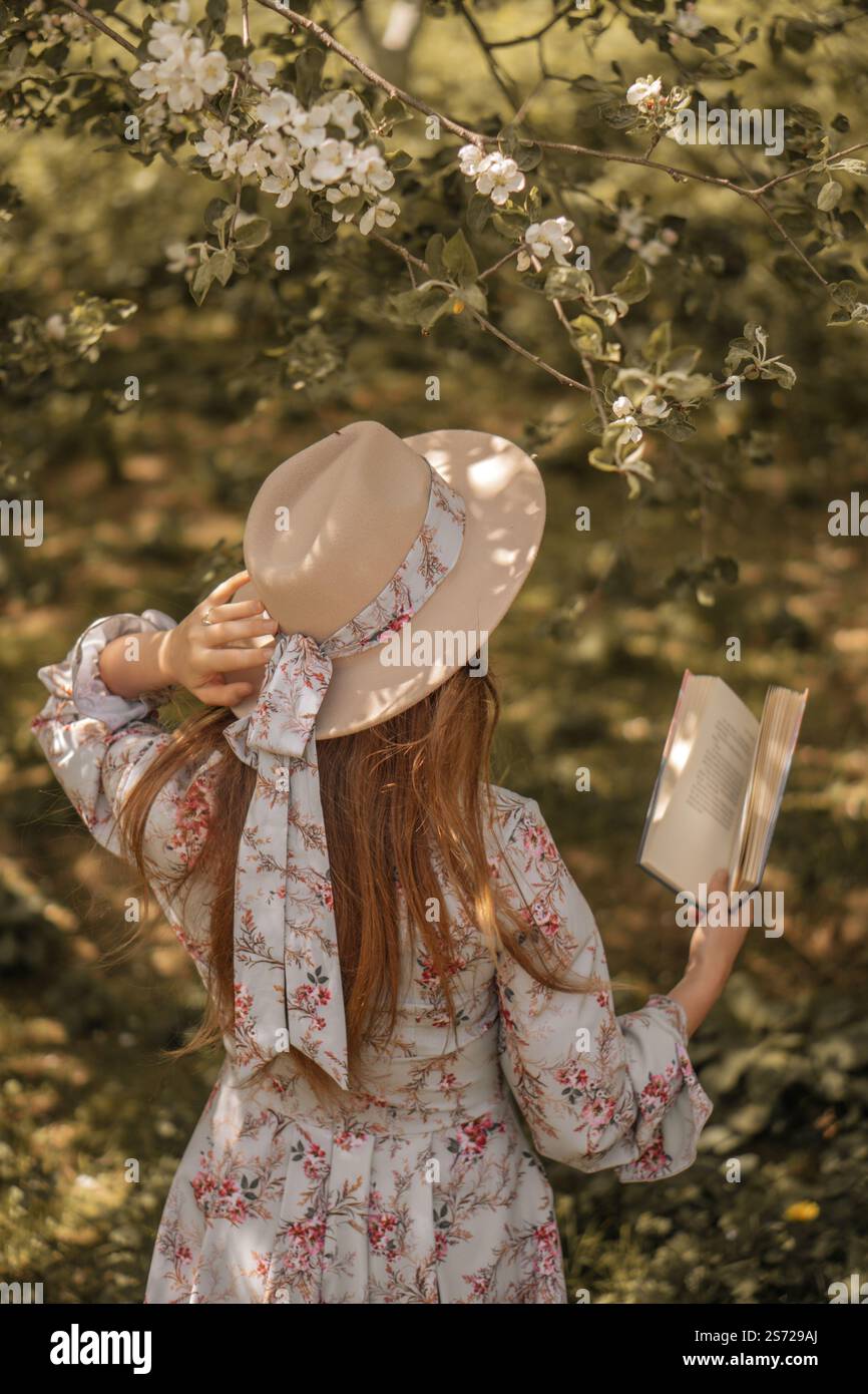 Lettura serena: Donna in cappello che gode della natura Foto Stock