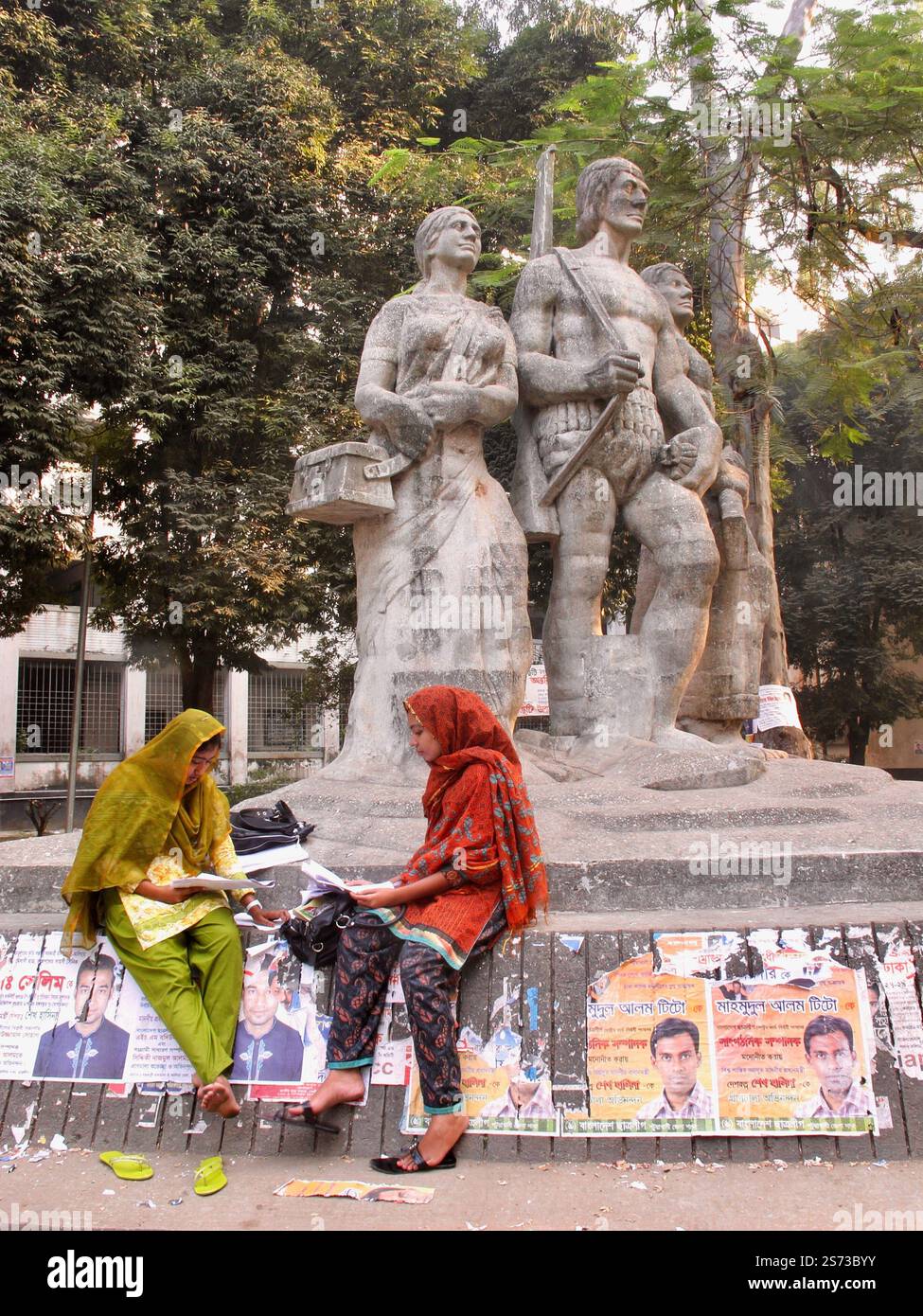 Due studentesse che leggono il monumento Aparajeyo Bangla all'Università di Dhaka, simboleggiando la guerra di liberazione e la cultura accademica del Bangladesh. Foto Stock