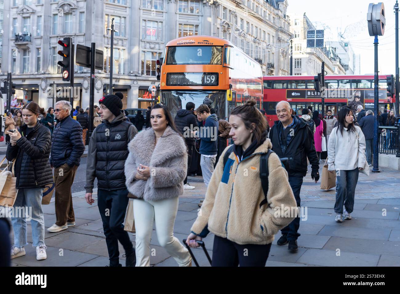 Londra, Regno Unito - 3 dicembre 2024, la folla cammina lungo Oxford Street durante l'ora di punta. Persone di razze diverse. Una donna con un cappotto di pelliccia sintetica è stan Foto Stock