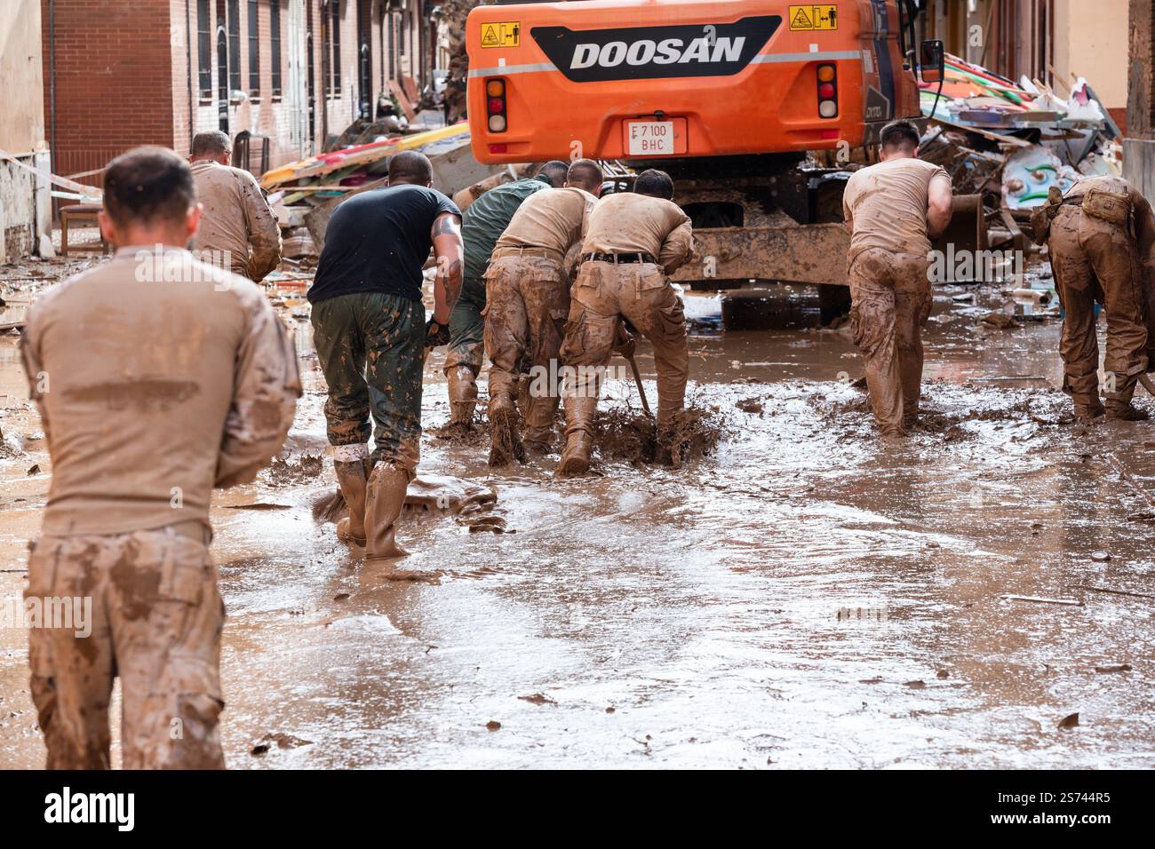 La fanteria dell'esercito spagnolo durante le operazioni di pulizia dopo le inondazioni DANA spazzare il fango dalle strade allagate. Paiporta, Spagna. Foto Stock