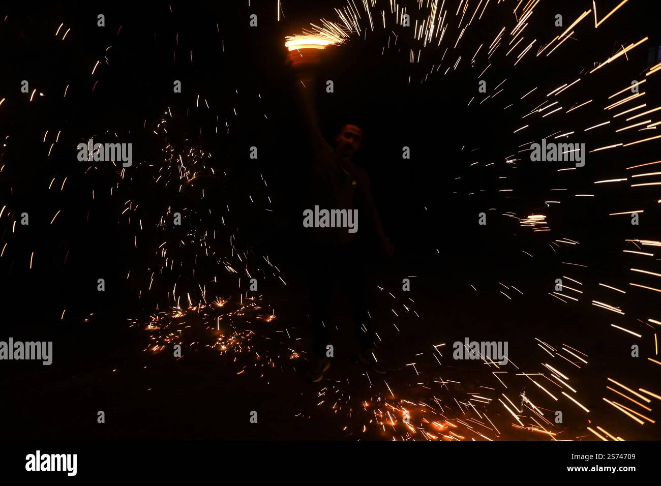 Un palestinese fa esplodere i fuochi d'artificio per festeggiare e rallegrarsi della cessazione della guerra nella Striscia di Gaza e del completamento dell'accordo di scambio di prigionieri tra il governo israeliano e il movimento di resistenza islamica Hamas nella Striscia di Gaza, entrato in vigore questa sera e che tutte le sue fasi sono state rispettate. I palestinesi e gli israeliani si stanno preparando ad accogliere i loro figli, prigionieri e detenuti, detenuti da entrambe le parti. Foto Stock
