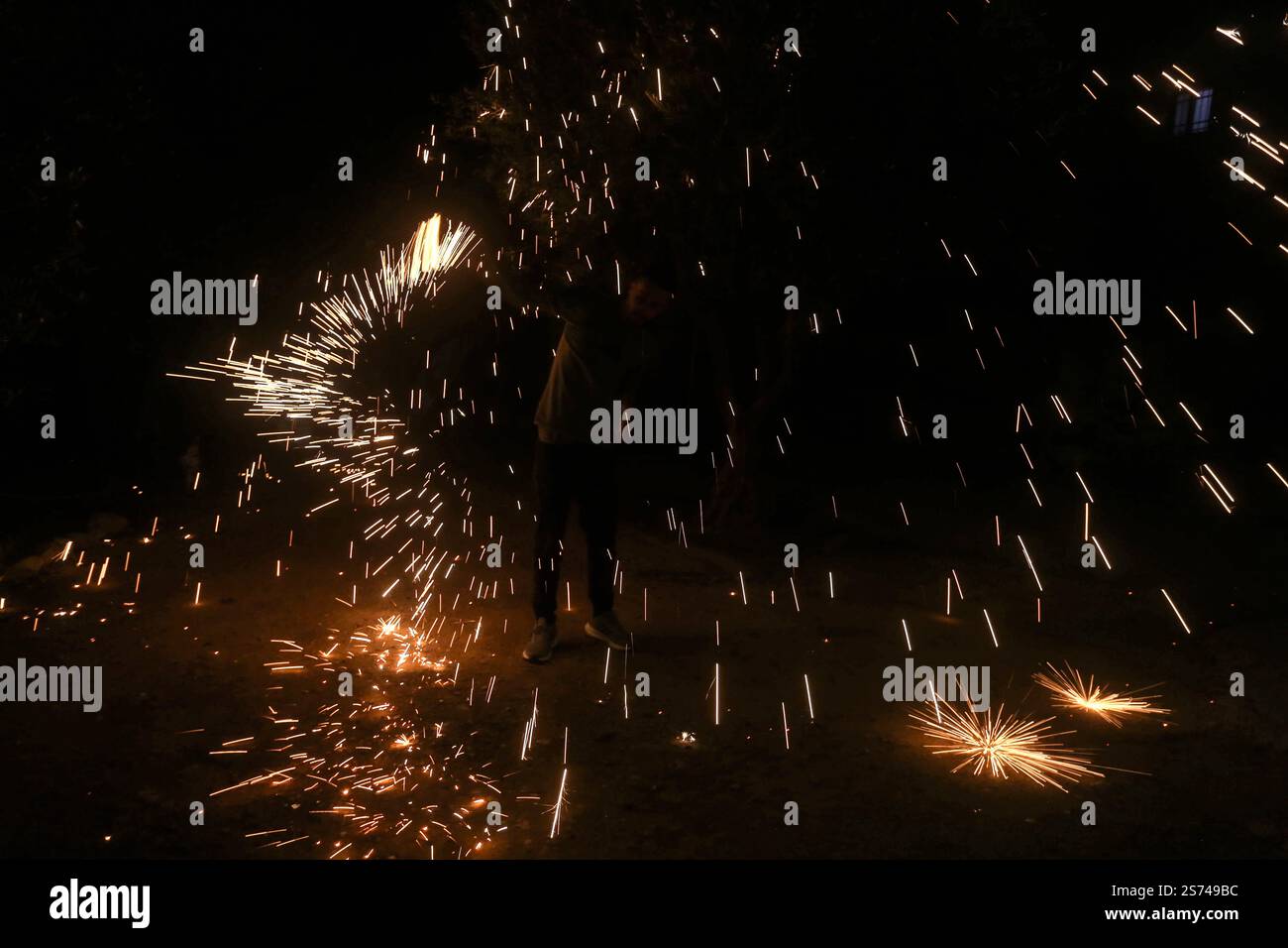 Nablus, Palestina. 18 gennaio 2025. Un palestinese fa esplodere i fuochi d'artificio per festeggiare e rallegrarsi della cessazione della guerra nella Striscia di Gaza e del completamento dell'accordo di scambio di prigionieri tra il governo israeliano e il movimento di resistenza islamica Hamas nella Striscia di Gaza, entrato in vigore questa sera e che tutte le sue fasi sono state rispettate. I palestinesi e gli israeliani si stanno preparando ad accogliere i loro figli, prigionieri e detenuti, detenuti da entrambe le parti. (Foto di Nasser Ishtayeh/SOPA Images/Sipa USA) credito: SIPA USA/Alamy Live News Foto Stock