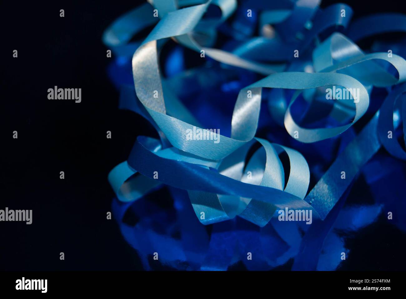 Eleganti nastri blu con finitura lucida, posizionati su una superficie riflettente. Foto Stock